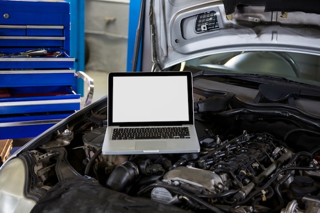 Computadora portátil en el capó del coche