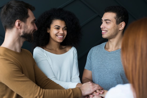 Comunidad de jóvenes positivos tomados de la mano