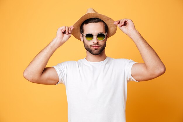 Concentrado joven parado aislado sobre pared naranja