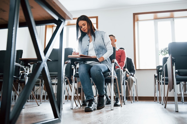 Concepción de la educación. Grupo de personas en conferencia de negocios en el aula moderna durante el día