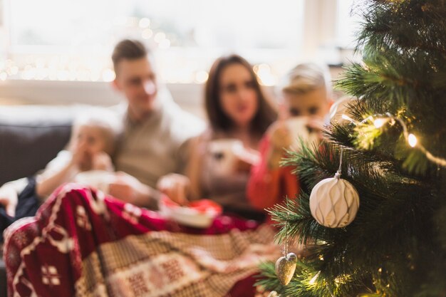 Concept de navidad con familia detrás de árbol de navidad