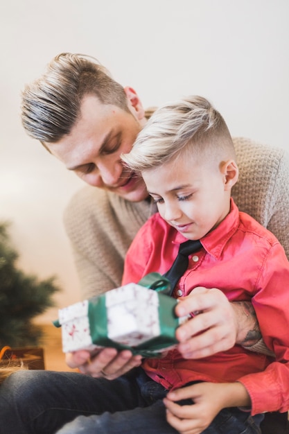 Foto gratuita concept de navidad con padre dando regalo a hijo