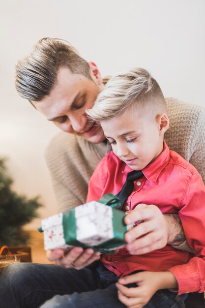 Concept de navidad con padre dando regalo a hijo