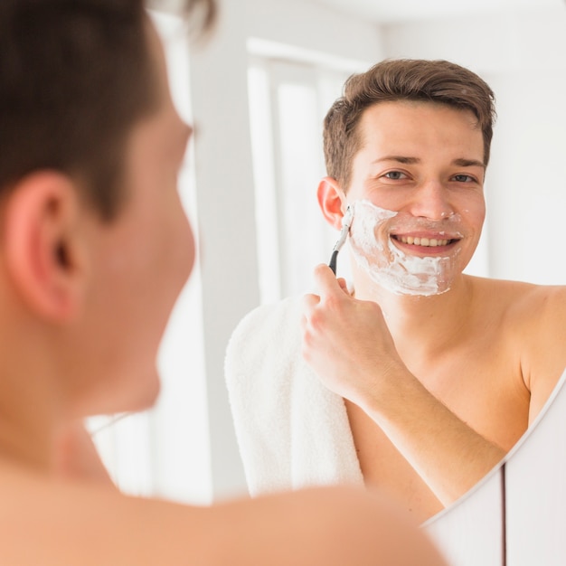 Foto gratuita concepto de afeitar con hombre atractivo joven