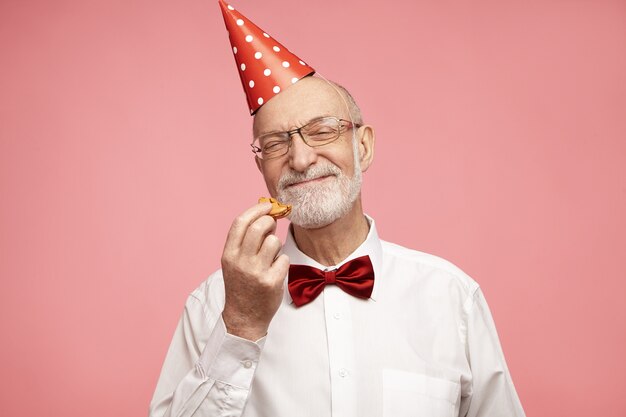 Concepto de alegría, diversión, celebración y felicidad. Chico feliz cumpleaños en sus setenta con aspecto alegre