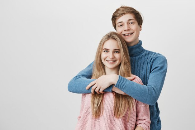 Concepto de amor, felicidad y relaciones. Feliz hombre caucásico con cabello rubio vestido con suéter azul