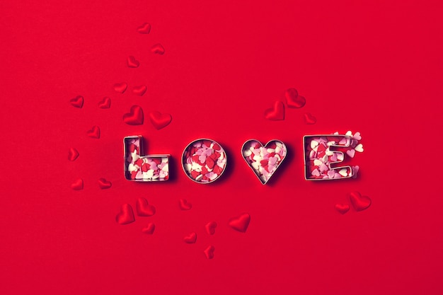 Concepto de amor con letras de amor y corazones sobre un fondo rojo. T