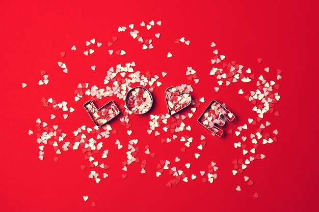 el concepto de amor con letras de AMOR y novios en un backgrou rojo