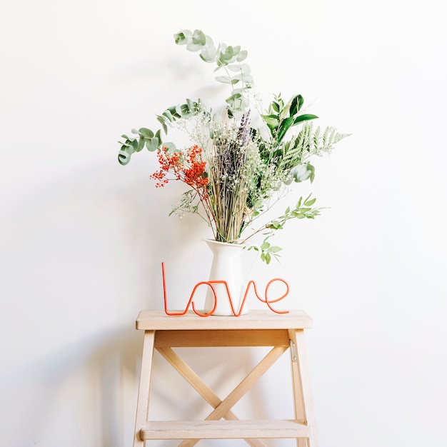 Foto gratuita concepto de amor con planta en taburete