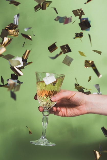 Foto gratuita concepto de año nuevo creativo con mano sujetando champán