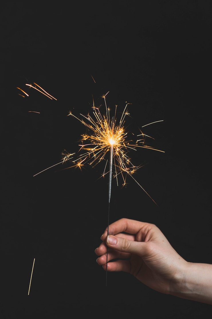 Foto gratuito concepto de año nuevo con mano sujetando bengala