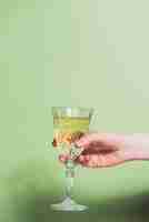 Foto gratuita concepto de año nuevo con mano sujetando vaso de champán
