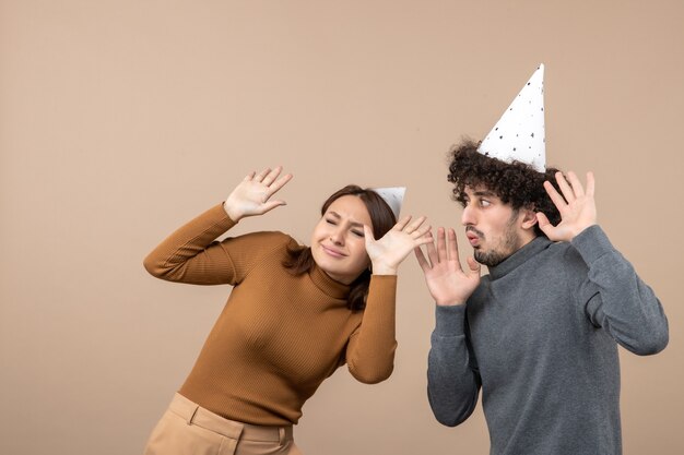 Concepto de año nuevo con pareja joven asustada usar chica de sombrero de año nuevo y chico en gris