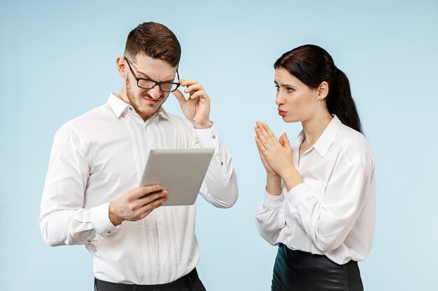 Concepto de asociación empresarial. Joven, emocional, hombre y mujer, contra, fondo azul