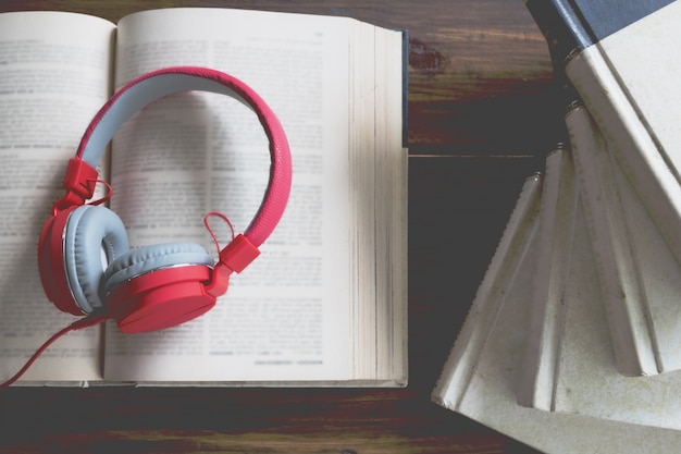 Concepto de audiolibro. Libros sobre la mesa con auriculares puestos en ellos.