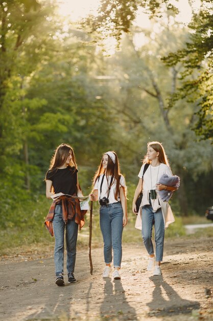 Concepto de aventura, viajes, turismo, caminata y personas. Tres chicas en un bosque.