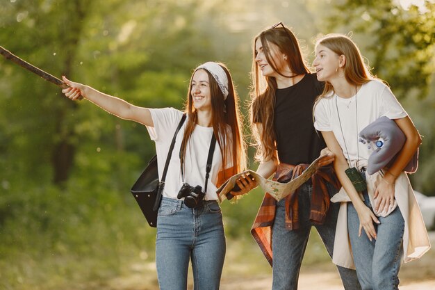 Concepto de aventura, viajes, turismo, caminata y personas. Tres chicas en un bosque.