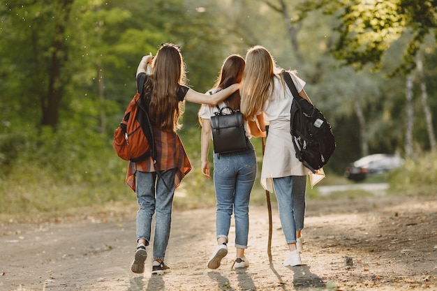 Concepto de aventura, viajes, turismo, caminata y personas. Tres chicas en un bosque.