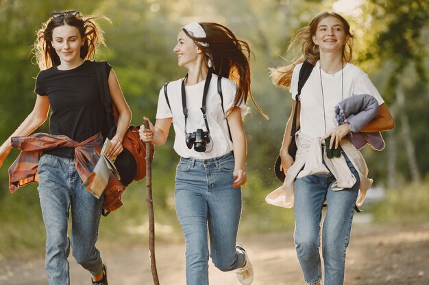 Concepto de aventura, viajes, turismo, caminata y personas. Tres chicas en un bosque.