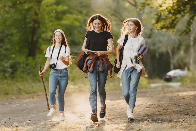 Concepto de aventura, viajes, turismo, caminata y personas. Tres chicas en un bosque.