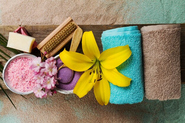 Concepto Del Balneario. Vista superior de productos hermosos del balneario con el lugar para el texto. Aceites esenciales con hermosas flores, toallas, sal de spa y jabón hecho a mano.