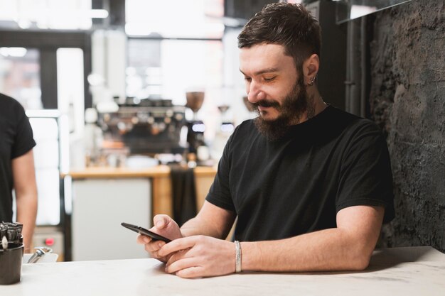 Concepto de bar con barista usando smartphone