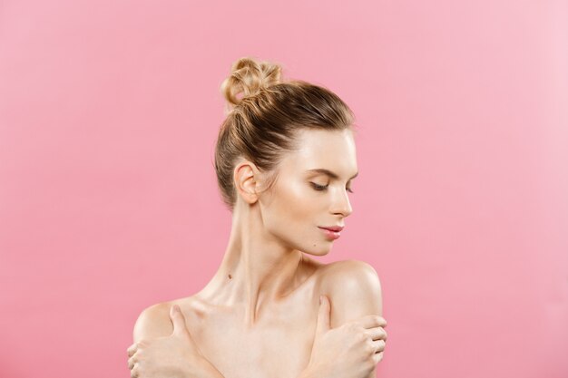 Concepto de belleza - Hermosa mujer con piel fresca limpia de cerca en el estudio de color rosa. Cara del cuidado de la piel. Cosmetología.