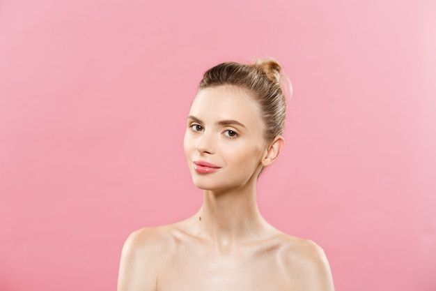 Concepto de belleza - Hermosa mujer con piel fresca limpia de cerca en el estudio de color rosa. Cara del cuidado de la piel. Cosmetología.