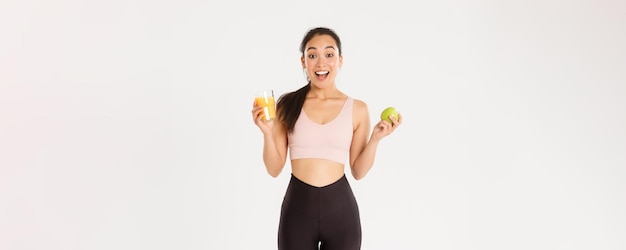 El concepto de bienestar deportivo y estilo de vida activo emocionó a la deportista asiática linda chica fitness con manzana