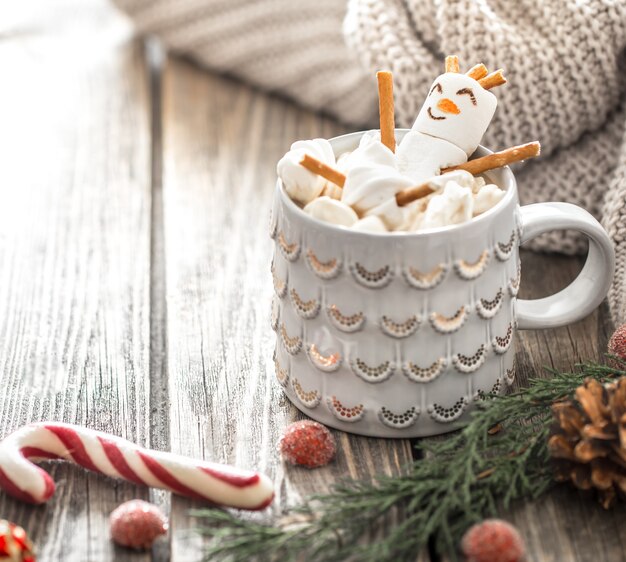 Concepto de cacao navideño con malvaviscos sobre un fondo de madera en un acogedor ambiente festivo