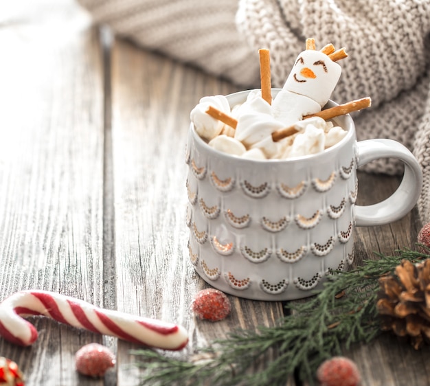 Concepto de cacao navideño con malvaviscos sobre un fondo de madera en un acogedor ambiente festivo