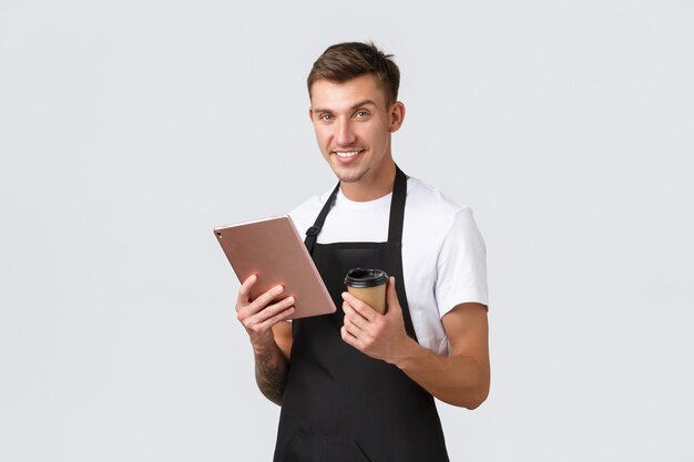 Concepto de cafetería y restaurante de cafetería pequeña empresa sonriente guapo camarero barista en negro apr ...
