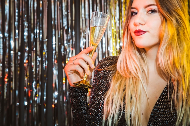 Foto gratuita concepto de celebración de año nuevo con mujer rubia sujetando vaso de champán