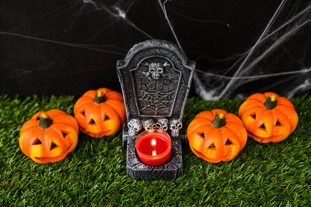 Concepto de cementerio de halloween con calabazas y vela