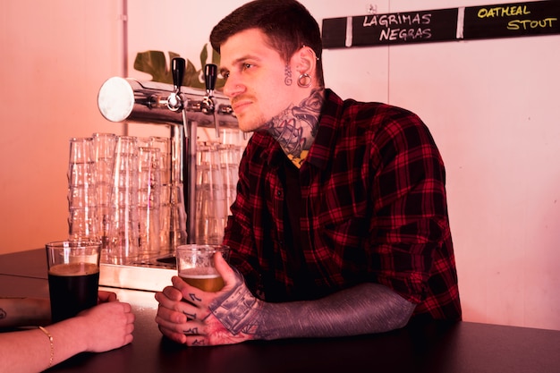 Foto gratuita concepto de cerveza artesana con hombre tatuado