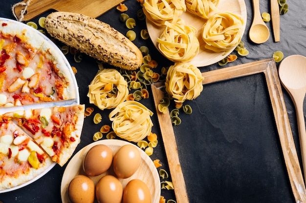 Concepto de comida italiana con pizarra, pizza y pasta