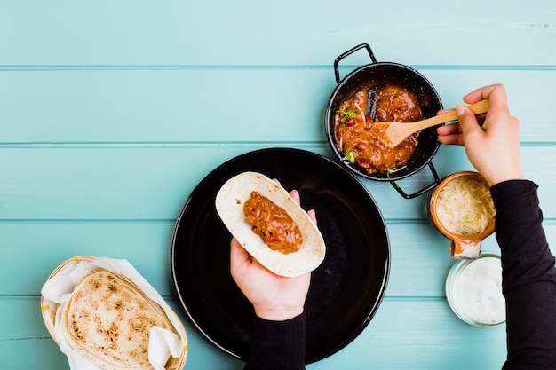 Concepto de comida mexicana con manos preparando burrito