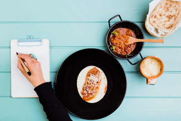Concepto de comida mexicana con manos preparando burrito