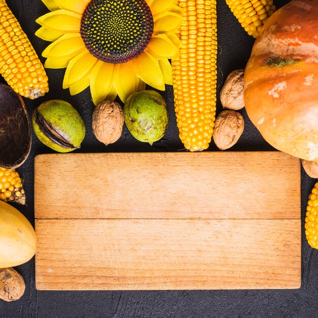 Concepto de comida de otoño con tabla de madera y girasol