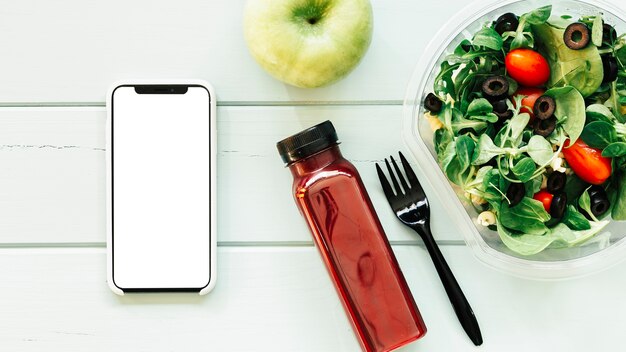 Concepto de comida sana con smartphone al lado de ensalada