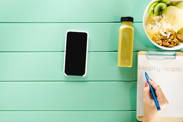 Foto gratuita concepto de comida sana con smartphone y clipboard