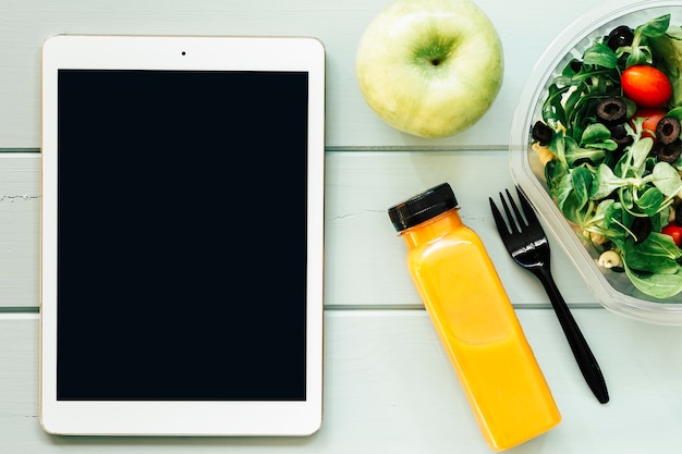 Foto gratuita concepto de comida sana con tablet y ensalada