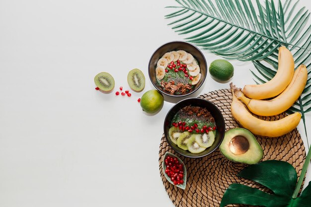 Concepto de comida sana. Vista superior de la mesa con tazones para batidos. Plato cubierto con kiwi, granola, granate, chía, aguacate.