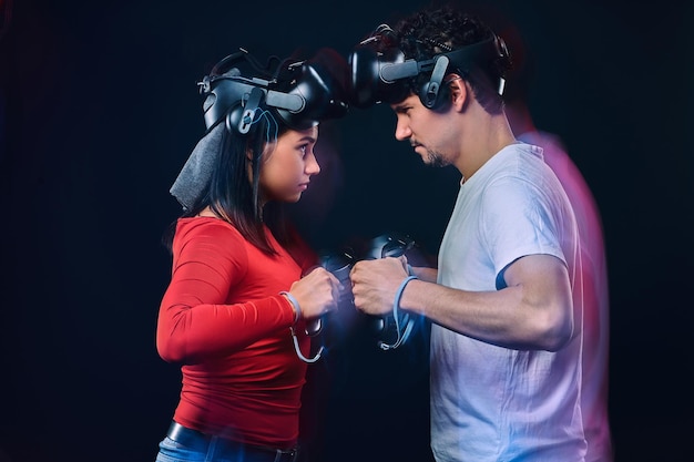 concepto de competencia y confrontación. Un par de jugadores profesionales con auriculares VR participan en la batalla del juego. Foto con efecto de luz.