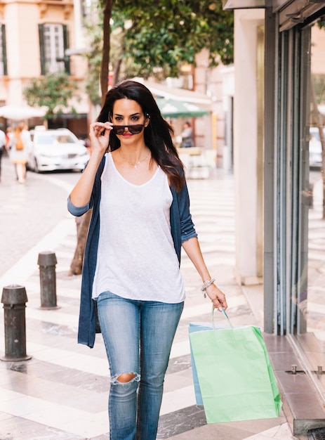 Concepto de compras con mujer llevando gafas de sol