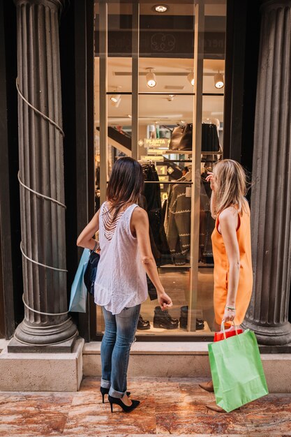 Concepto de compras con mujeres enfrente de tienda