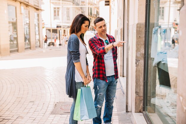 Concepto de compras con pareja mirando tiendo de moda