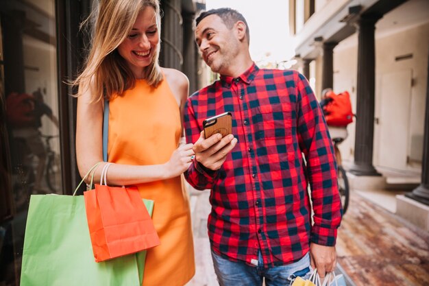 Concepto de compras con pareja sujetando smartphone