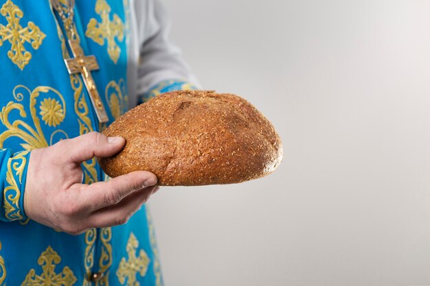 Concepto de comunión con sacerdote sosteniendo pan