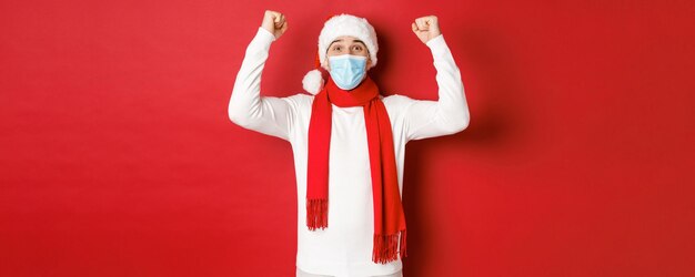 Concepto de covid navidad y vacaciones durante la pandemia retrato de hombre feliz con sombrero de santa y médico